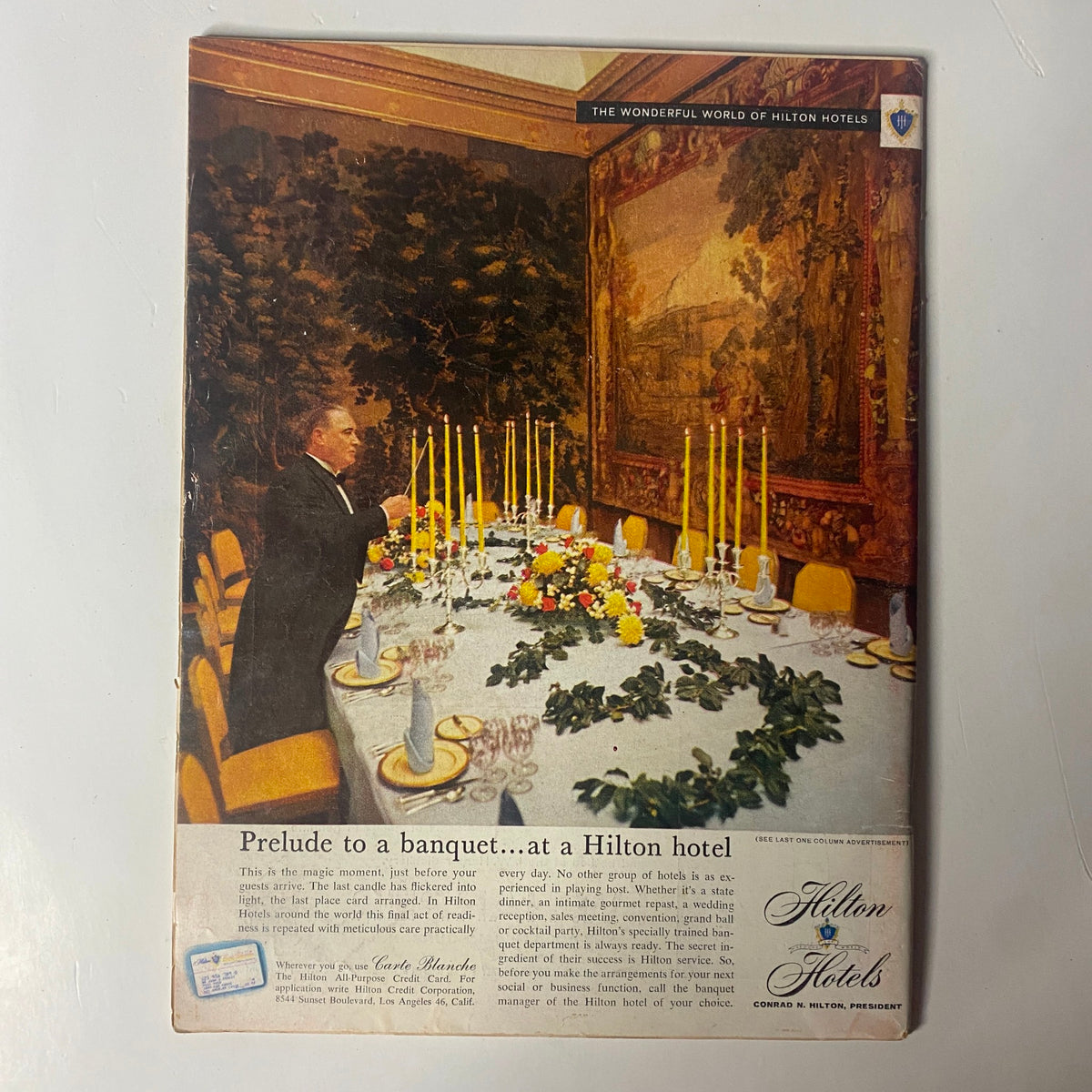 Promotional image for Hilton Hotels featuring a lavish banquet setup. The scene showcases an elegantly decorated dining table with candles and floral arrangements. The title 'Prelude to a banquet…at a Hilton hotel' is prominent, highlighting luxurious dining experiences.
