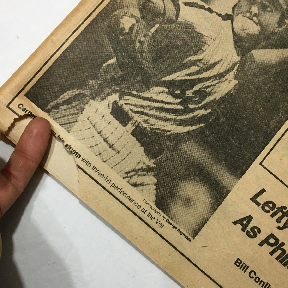 Close-up image of a vintage newspaper from August 30, 1982 showing a baseball player alongside text mentioning Bill Conlin's performance, highlighting minor wear and a small rip.