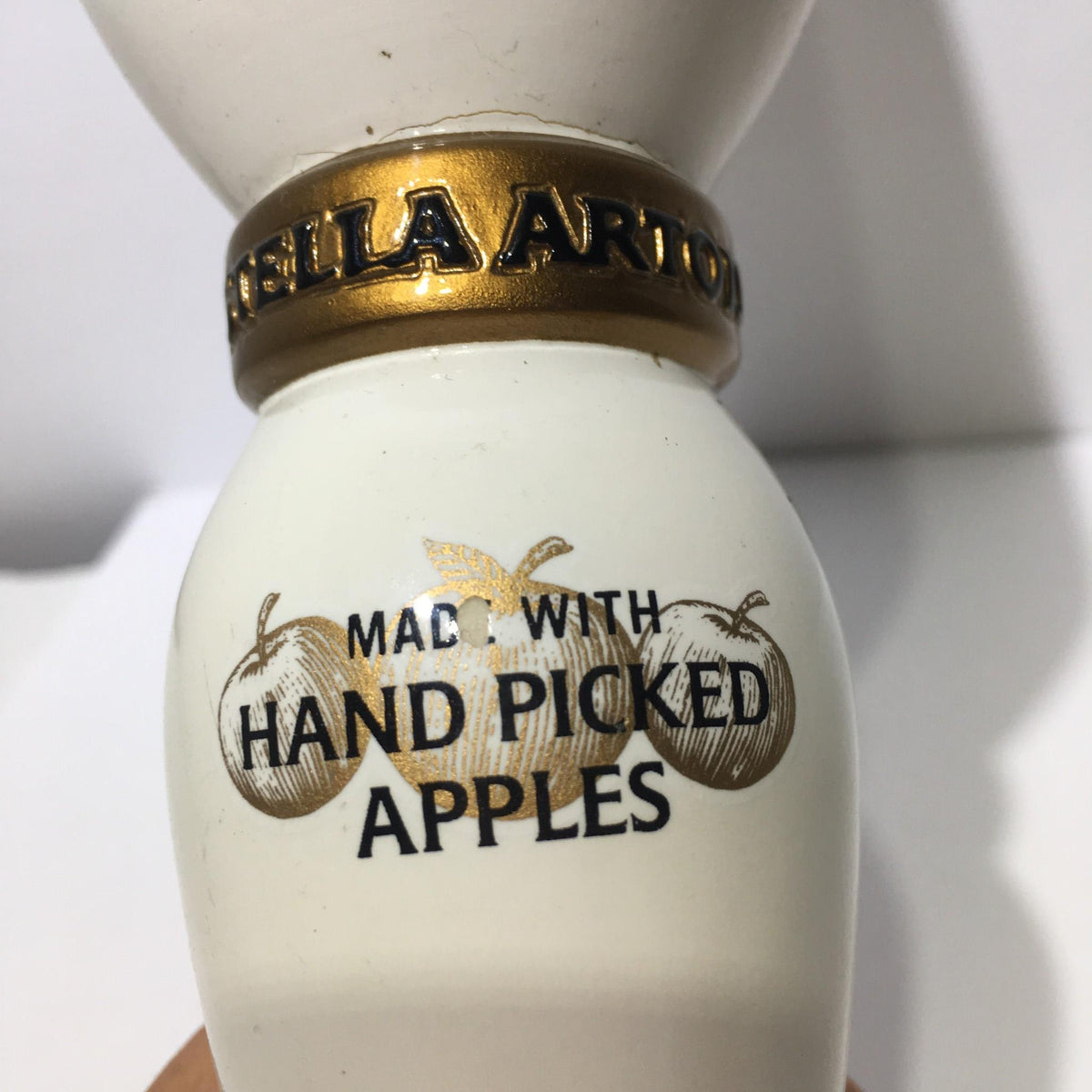 Close-up view of the neck of a Vintage Stella Artois Cidre 10" Beer Tap Handle highlighting the 'Made with Hand Picked Apples' inscription.