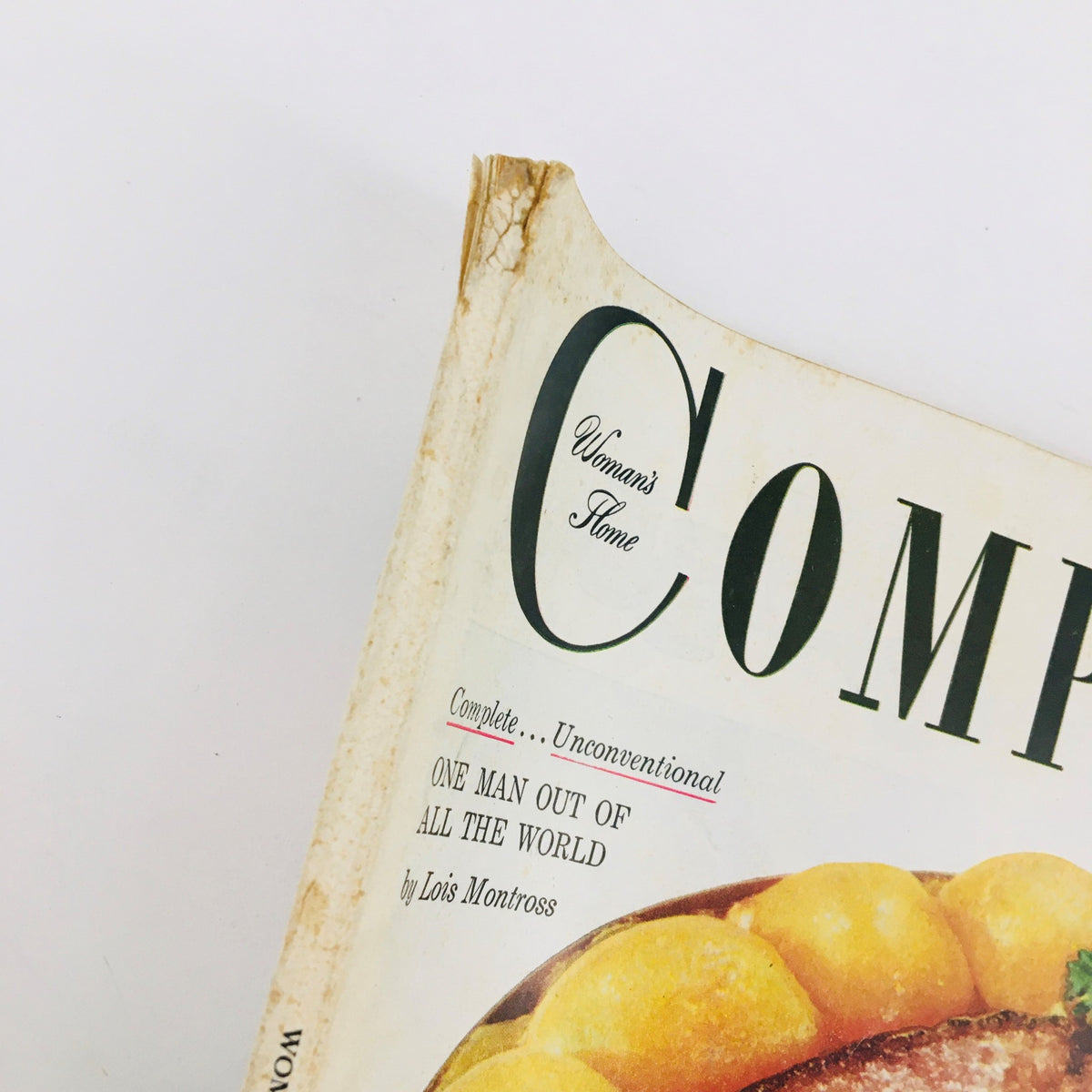 Close-up detail of Woman's Home Companion November 1952 cover, illustrating the title 'One Man Out Of All The World' by Lois Montross, highlighting its vintage design and condition with minor wear.