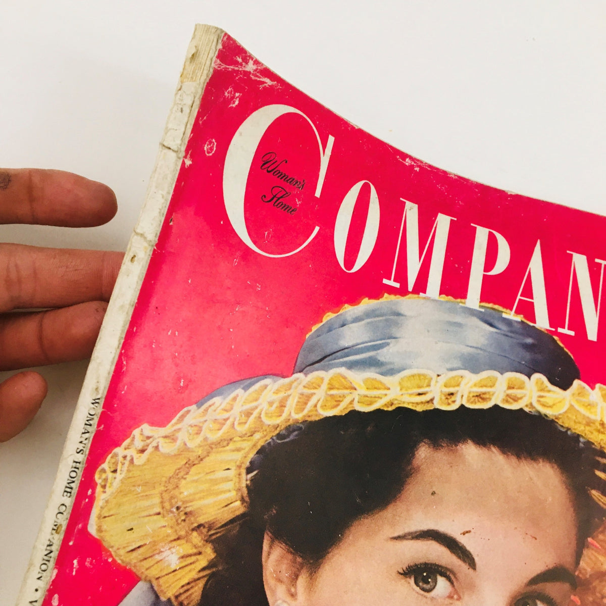 Close-up of the Woman's Home Companion April 1953 cover, highlighting the title and the woman in a fashionable hat, showcasing retro design elements.