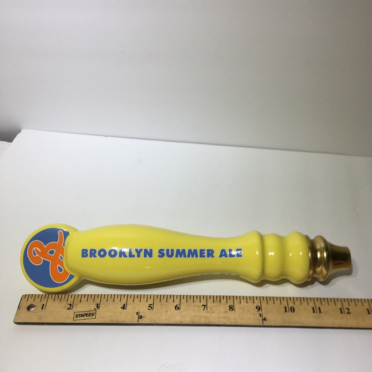 Top view of Vintage Brooklyn Summer Ale 12½" beer tap handle, highlighting the unique curve and bright yellow color, great for beer enthusiasts.