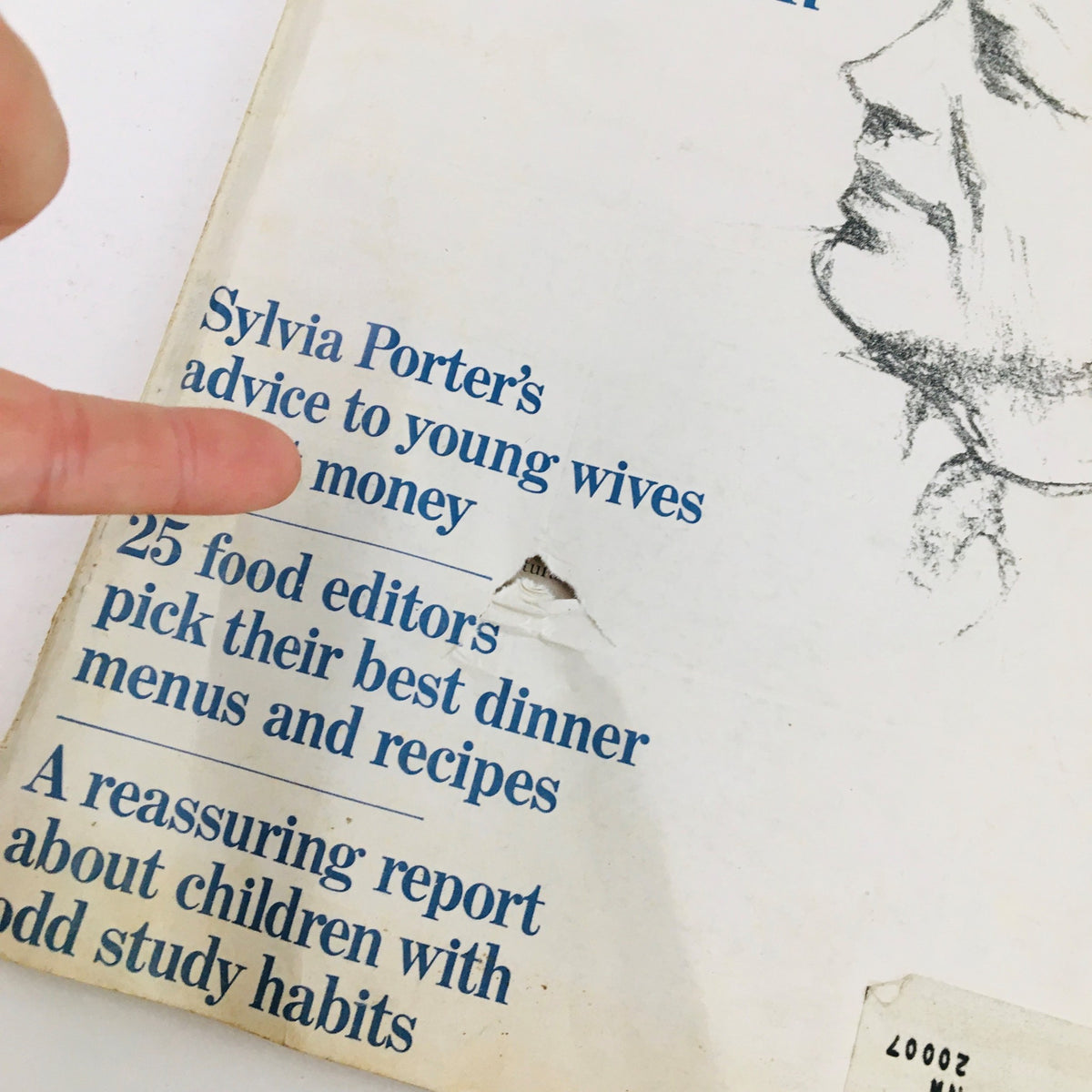 Close-up of Redbook Magazine November 1964 featuring articles like Sylvia Porter's advice to young wives on money, alongside visible wear and tear, showcasing its vintage character.