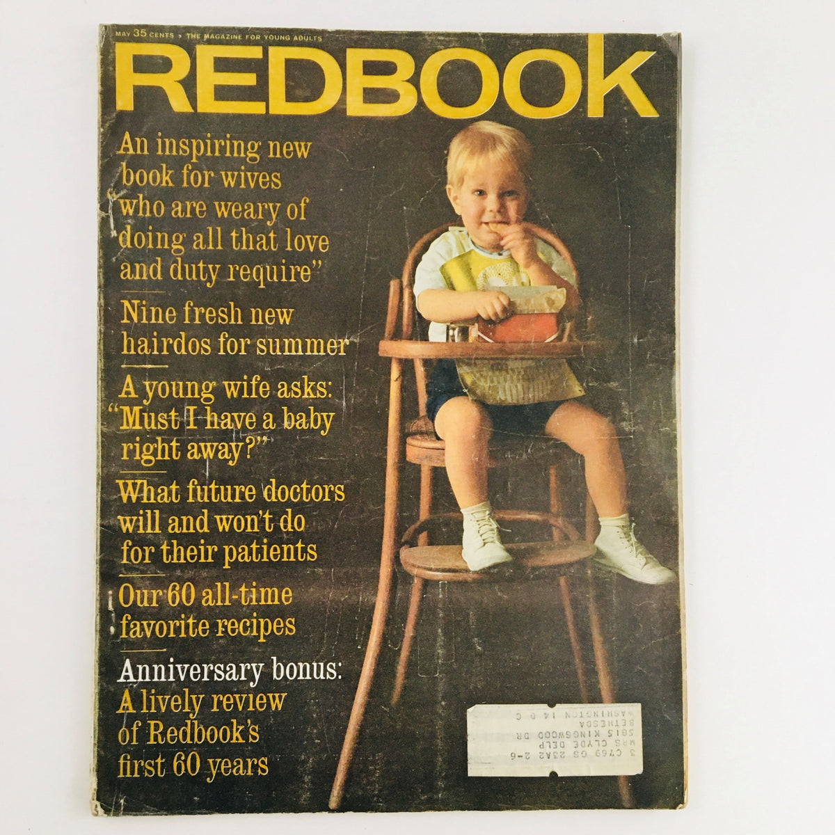 Cover of Redbook Magazine May 1963 featuring a child in a high chair holding a toy, showcasing topics related to family life, health advice, and recipes.