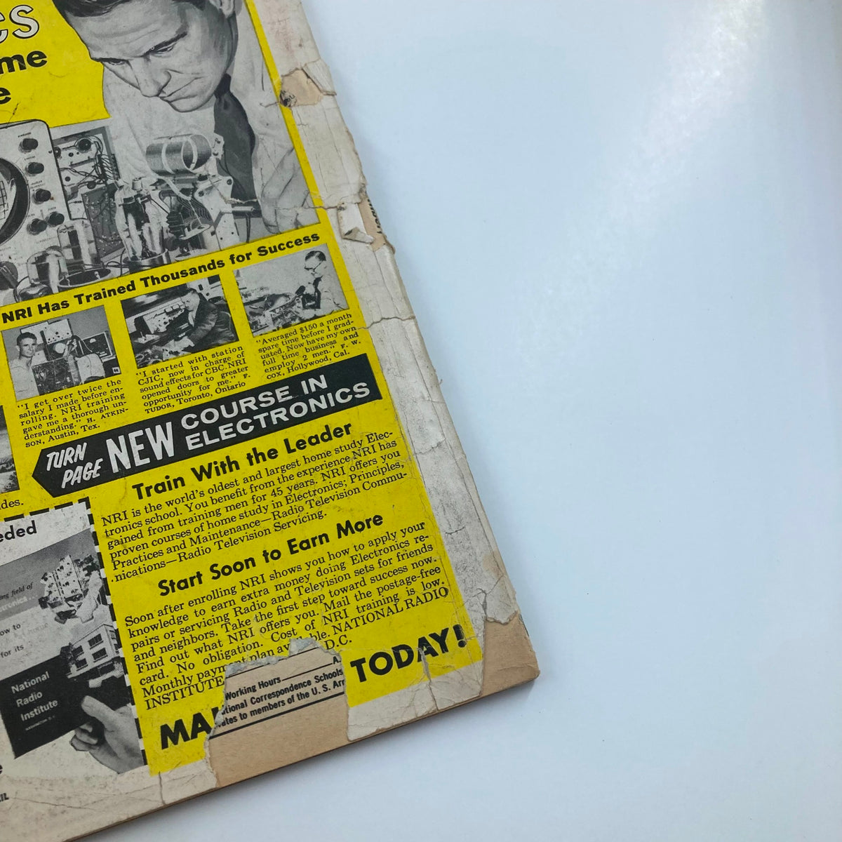 Back cover of VTG Stag Magazine December 1960 Vol 11 #12 titled 'Escape From Hell Island', featuring an advertisement for electronics training courses, with yellow and black design, showcasing various images and text related to the National Radio Institute.