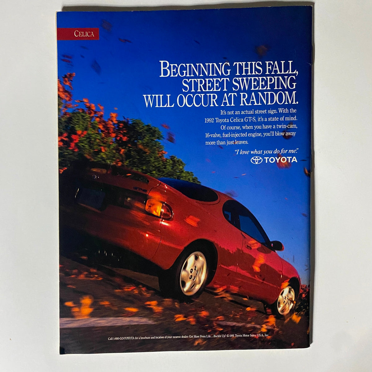Toyota Celica GTS advertisement showcasing a red car among autumn leaves. The ad emphasizes the car's powerful twin-cam engine and stylish design, appealing to automotive enthusiasts.