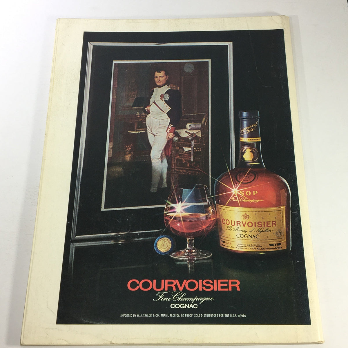 Advertisement for Courvoisier Fine Champagne Cognac in VTG Gourmet Magazine - November 1976, showcasing a rich glass of cognac beside a portrait of Napoleon.