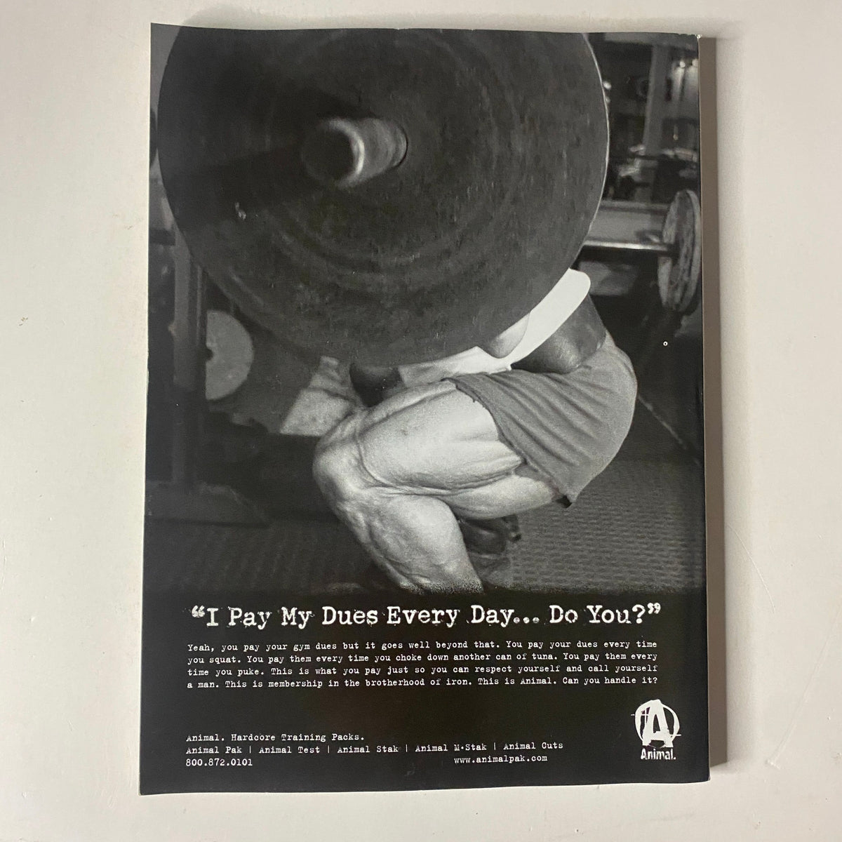 MuscleMag International Magazine October 2004, featuring a powerful black and white advertisement with the text 'I Pay My Dues Every Day... Do You?' showcasing a bodybuilder performing a squat with heavy weights, emphasizing dedication in training.