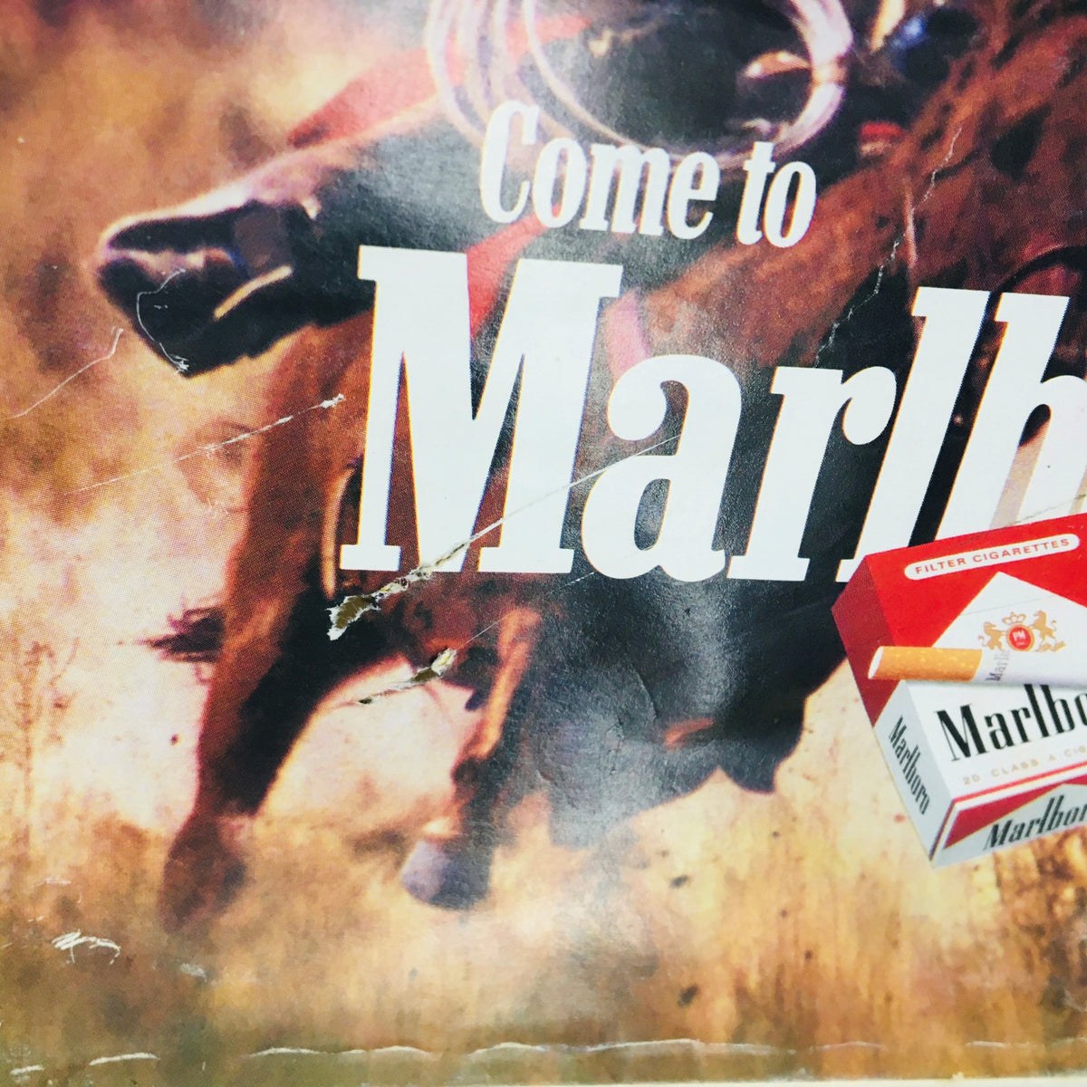Close-up of the Marlboro advertisement showing the slogan 'Come to Marlboro Country' with a pack of Marlboro cigarettes.