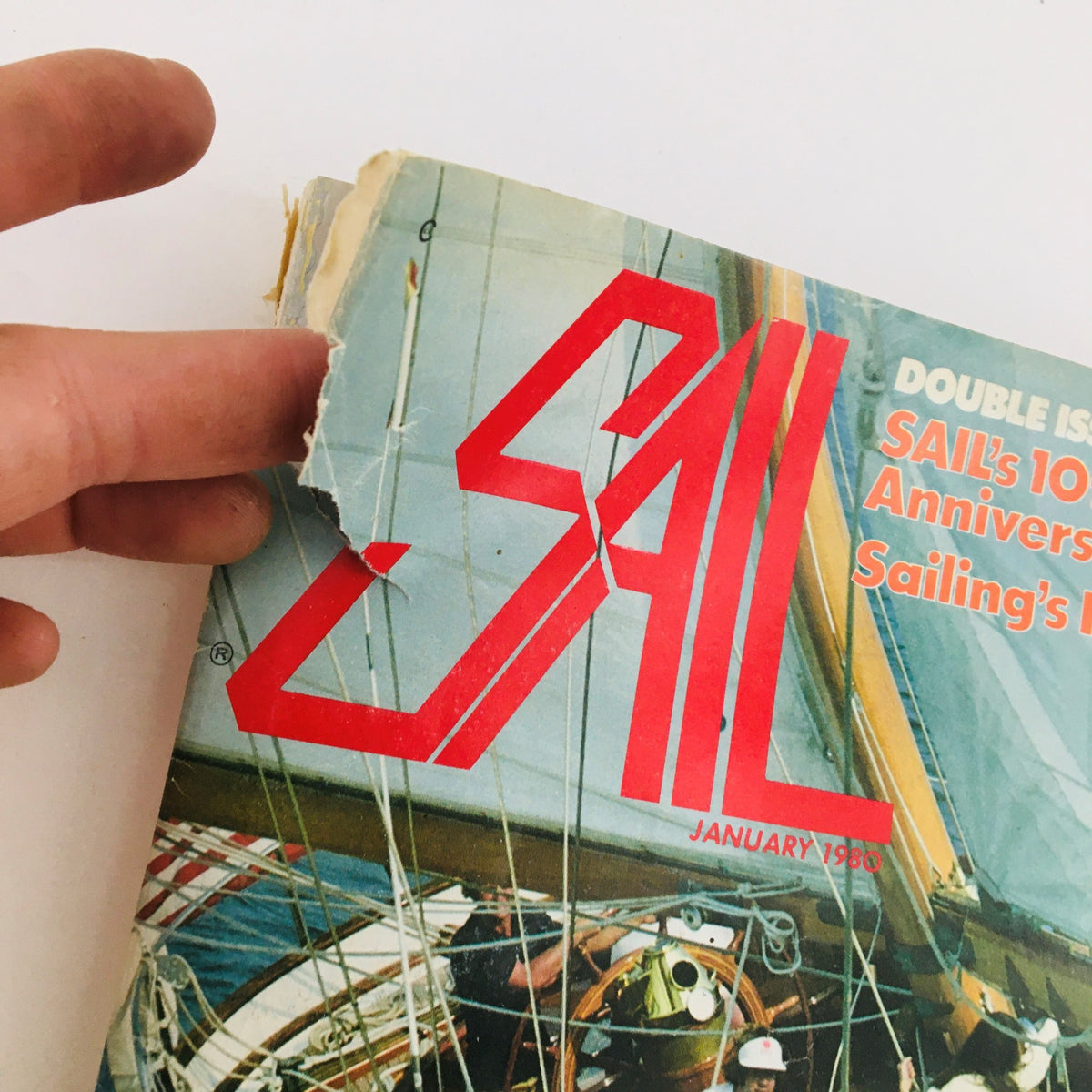Close-up of the torn corner of Sail Magazine January 1980, highlighting the title 'Sail's 10th Anniversary Sailing's New Wave' about the sailing culture of the era.
