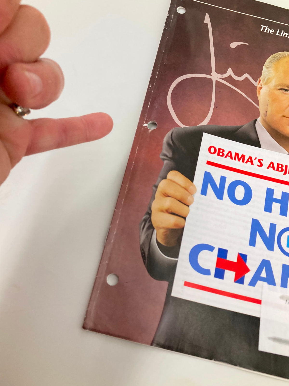 A hand gesture pointing at the cover of the Rush Limbaugh Letter Magazine from June 2016, emphasizing the message 'Obama's Abject Failure: No Hope No Change', showcasing the magazine's political commentary.