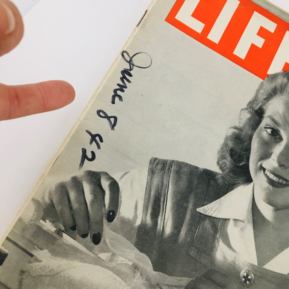 Close-up view of the cover of VTG Life Magazine June 8 1942 Nurses' Aide at World War II showing handwritten date and a woman's hand in a nurse's outfit.