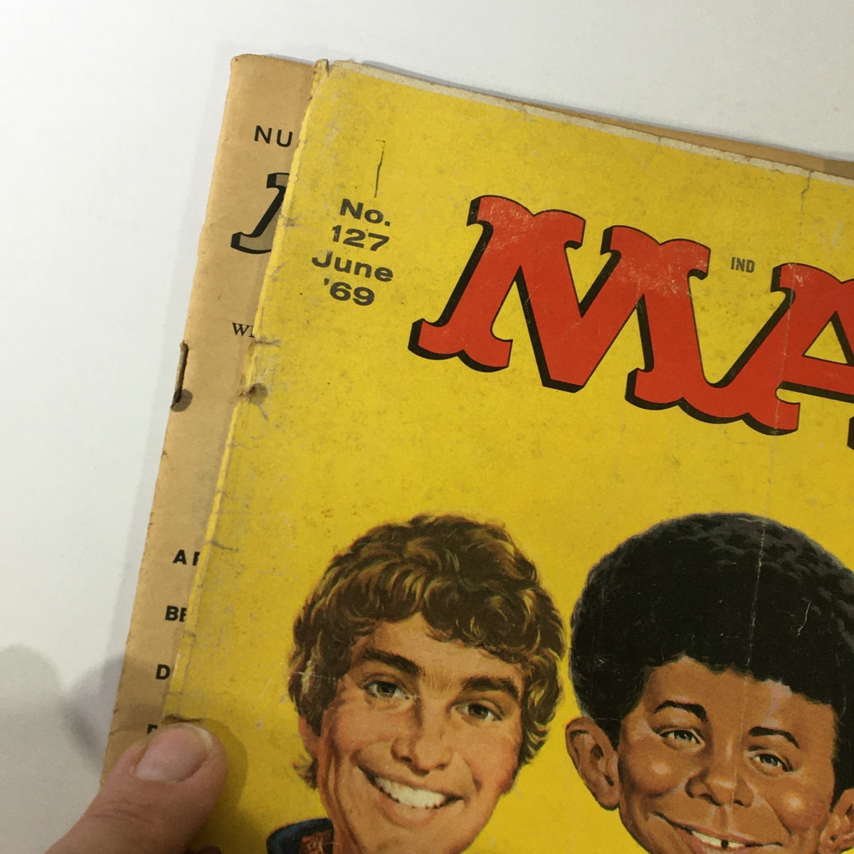 Close-up of the cover of Mad #127 June 1969, focusing on the title and character details, showcasing minor wear.