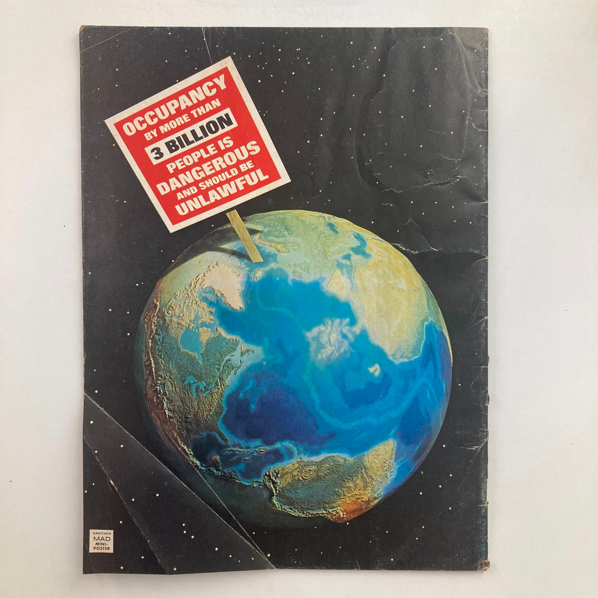 Back cover of Mad Magazine July 1975 No. 176, showing an artistic depiction of the Earth with a satirical sign discussing overpopulation, matching the magazine's humorous critique of societal issues.