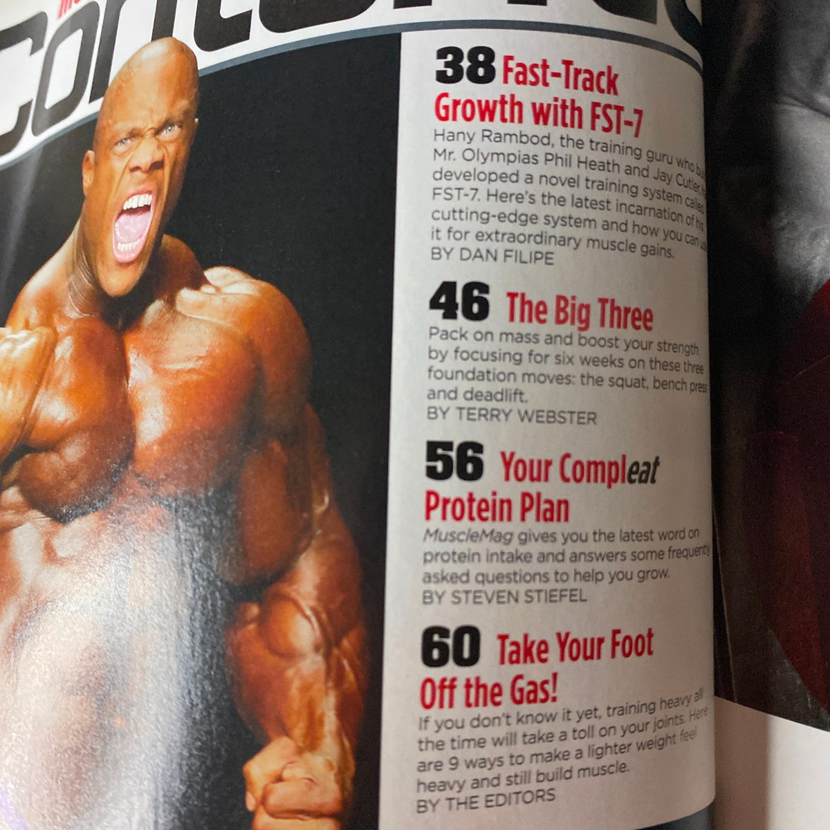 Inside page of MuscleMag International Magazine November 2013 highlighting fitness topics, including Fast-Track Growth with FST-7, featuring insights from Phil Heath.
