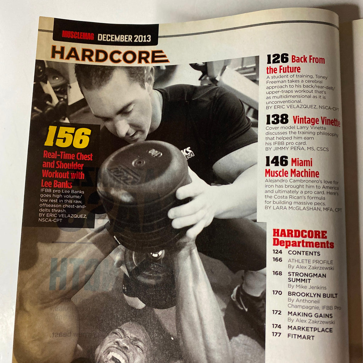Hardcore section of MuscleMag International Magazine December 2013 with an image of a bodybuilder performing a workout. Highlights fitness articles on chest and shoulder workouts. Title: MuscleMag International Magazine December 2013 Larry Vinette No Label VG.