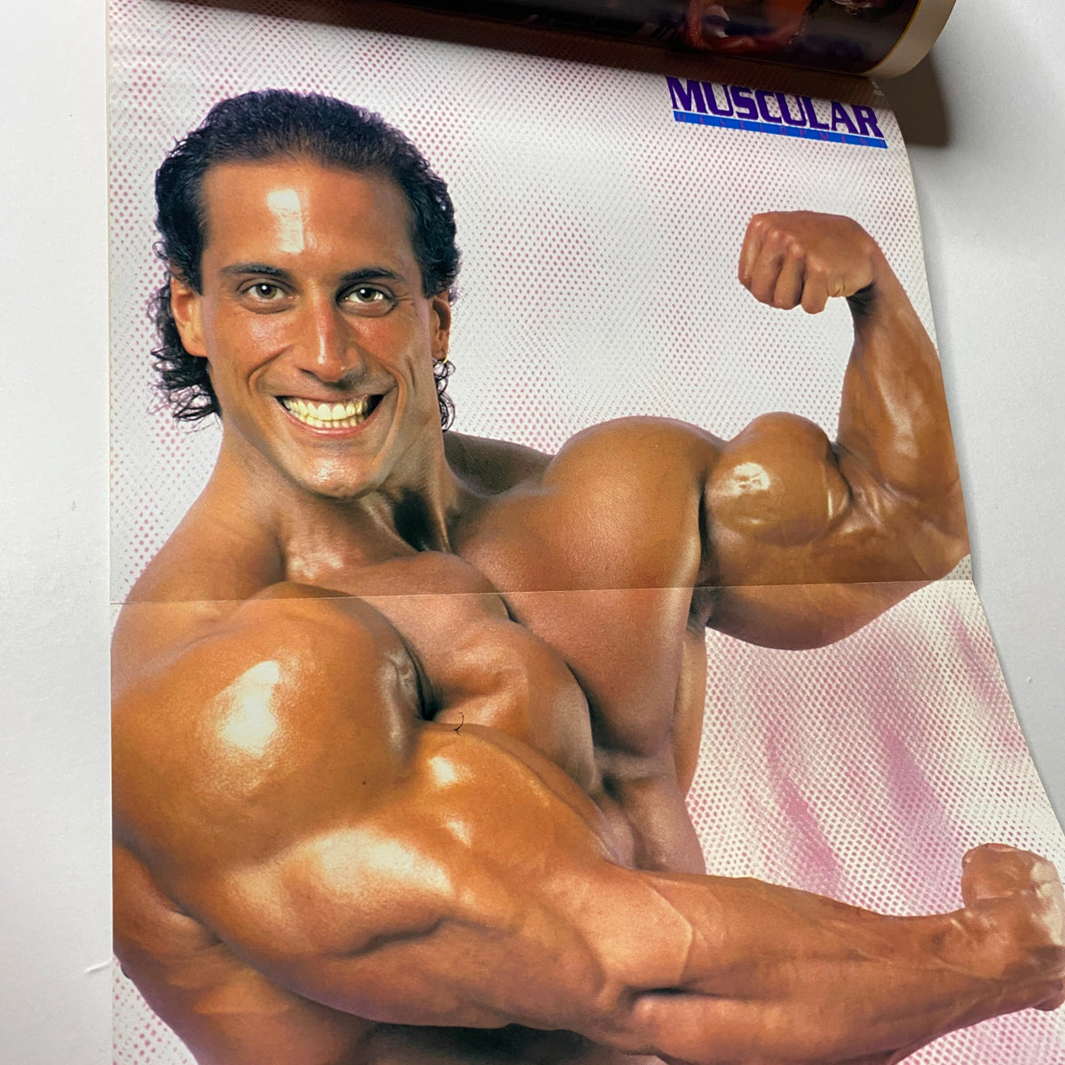 Centerfold poster of Mike Quinn flexing his muscles in Muscular Development Magazine April 1990, highlighting his impressive physique.