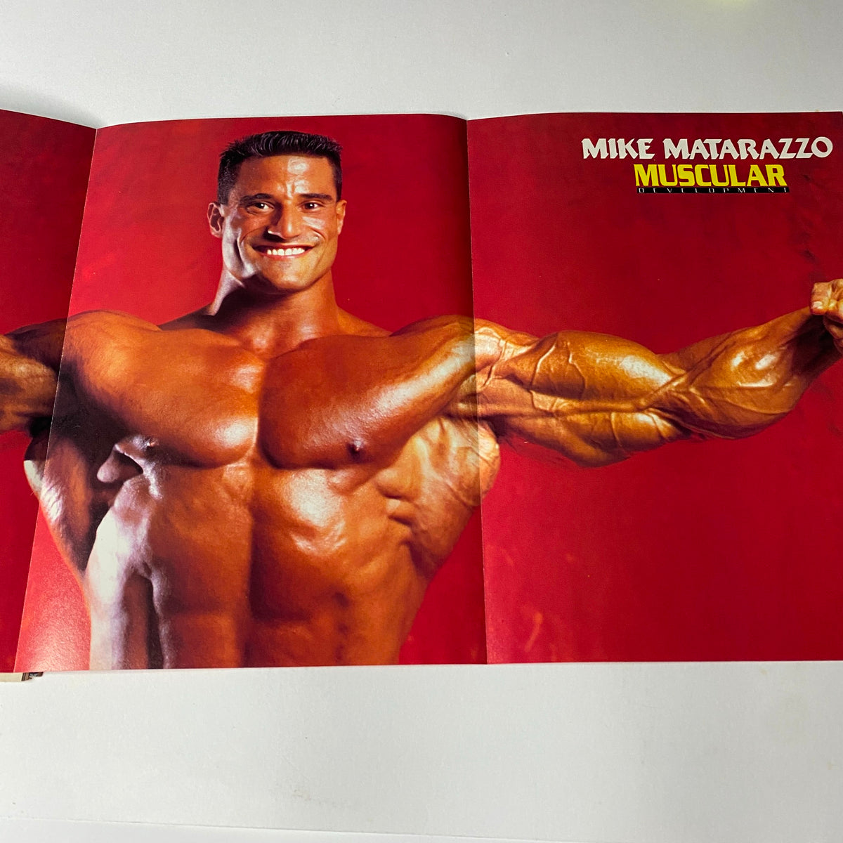 Inside spread of Muscular Development Magazine, March 1992, featuring Mike Matarazzo flexing his muscles. Highlights the bodybuilding theme and showcases Matarazzo's physique.