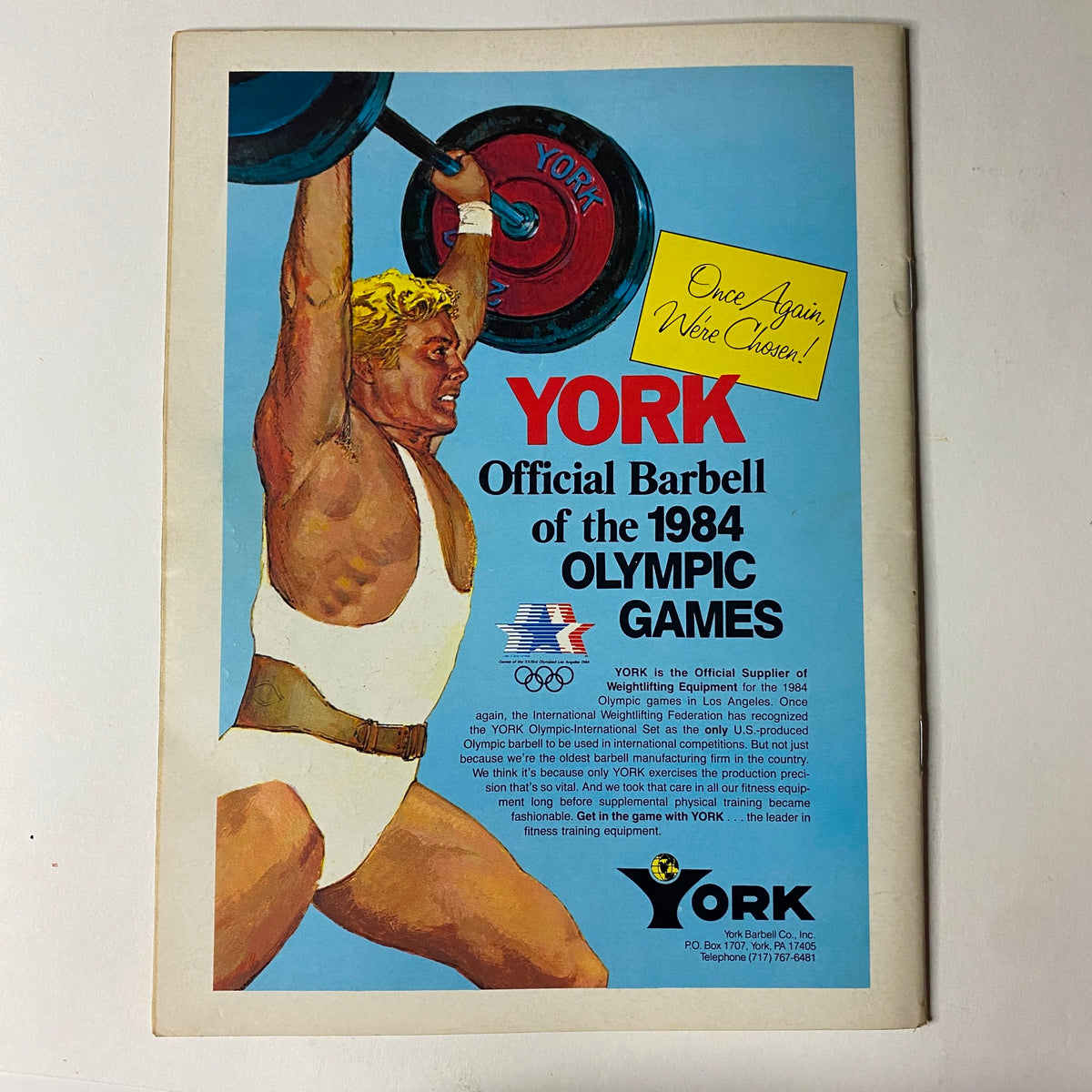 Muscular Development Magazine April 1983 advertisement for York Barbell, promoting its association with the 1984 Olympic Games with a muscular athlete lifting weights.