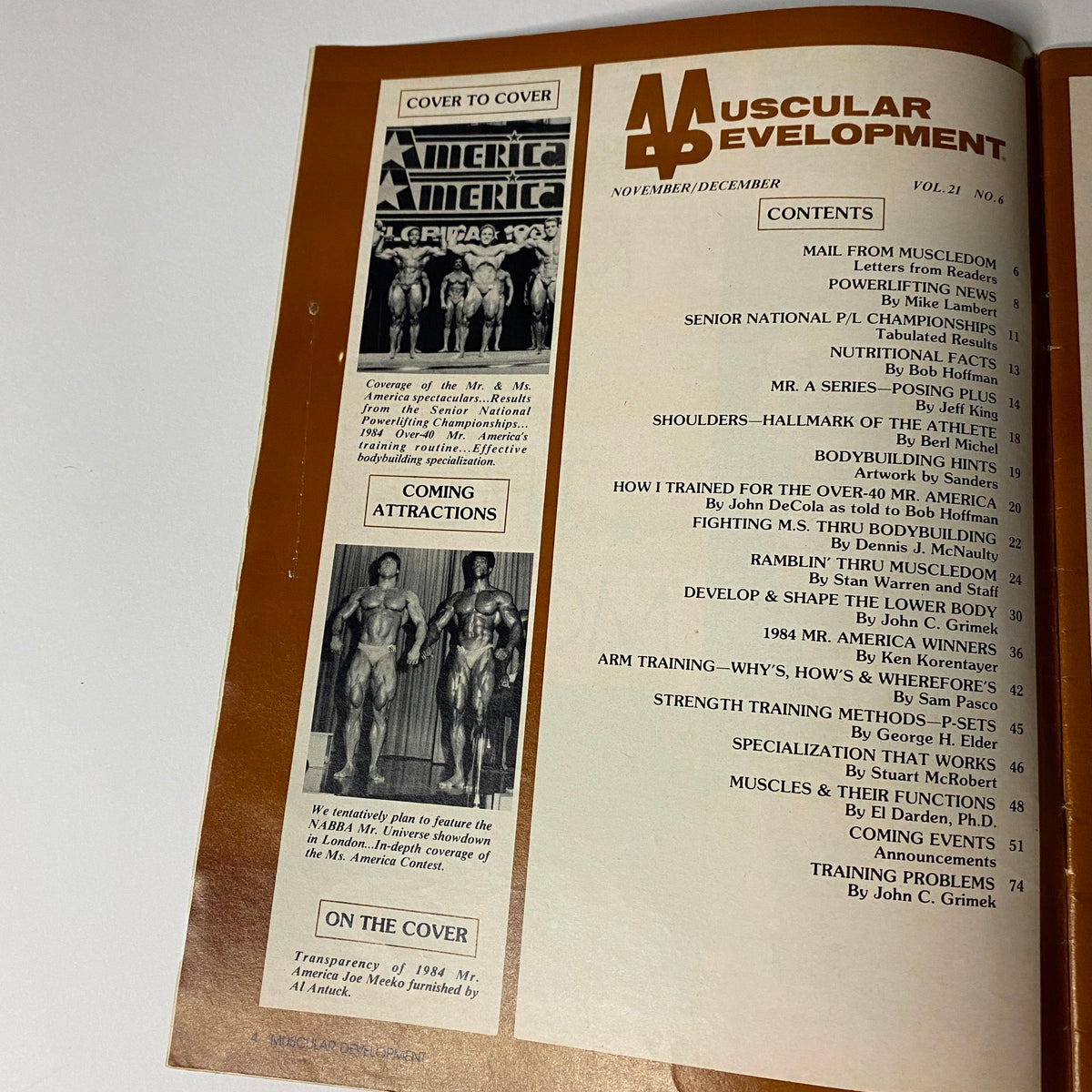Interior page of Muscular Development Magazine December 1984 displaying the table of contents, including features like 'MAIL FROM MUSCLEDOM' and 'ARM TRAINING—WHY’S, HOW’S & WHEREFORE’S'.