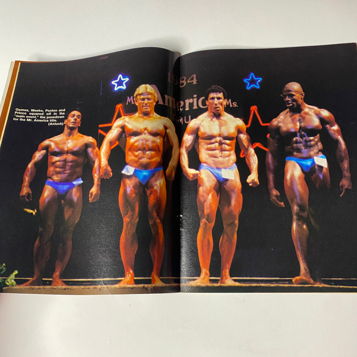 Muscular Development Magazine December 1984 featuring Joe Meeko with Mr. America contest competitors posing on stage, showcasing muscular physiques in blue swimwear.