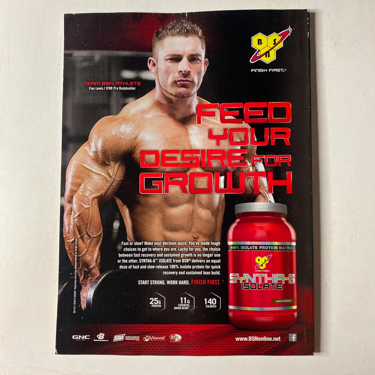 Advert for BSN's Synthax protein featured in MuscleMag International Magazine July 2014, promoting muscle growth with an image of a bodybuilder showcasing defined arms and strength.