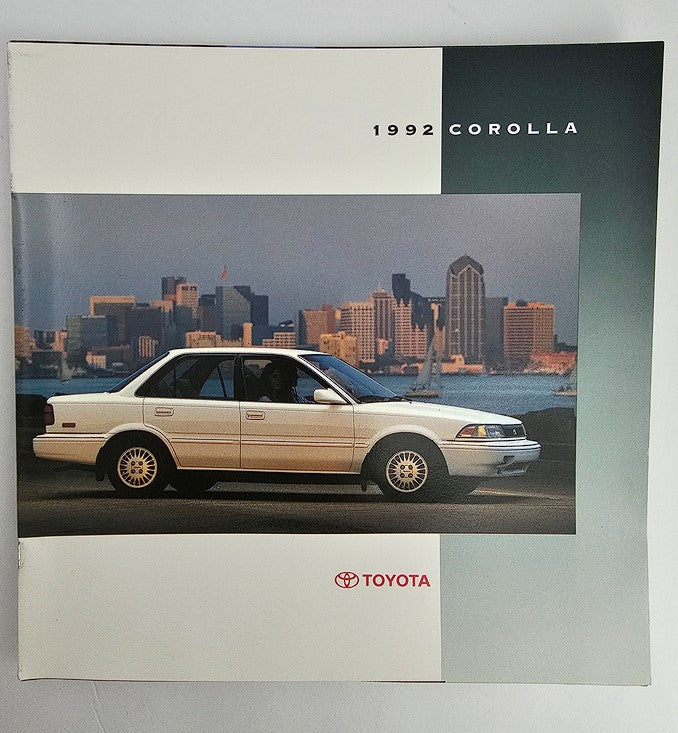 Cover of the 1992 Toyota Corolla Sedan Dealer Showroom Sales Brochure Guide Catalog featuring a white Toyota Corolla against a scenic city skyline in the background.