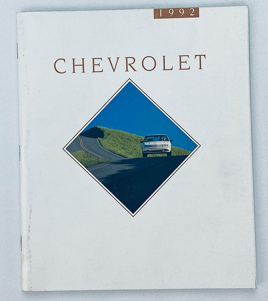 Cover of the 1992 Chevrolet Dealer Showroom Sales Brochure Guide Catalog featuring a sleek car on a winding road, showcasing Chevrolet branding and design elements.