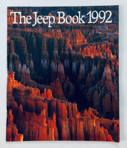 Cover of the 1992 The Jeep Book Dealer Showroom Sales Brochure Guide Catalog featuring dramatic red rock formations, showcasing the beauty and rugged terrain associated with Jeep vehicles.
