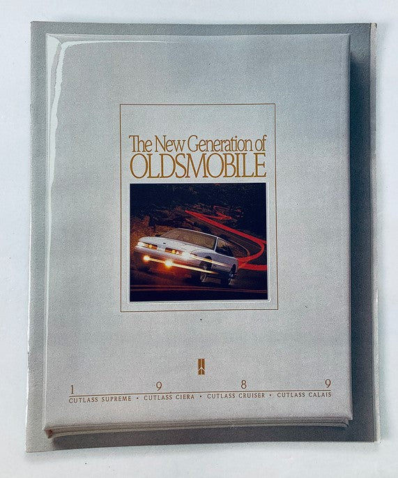 1989 Oldsmobile Cutlass Ciera Dealer Showroom Sales Brochure showcasing the new generation of Oldsmobile vehicles in a protective plastic covering.