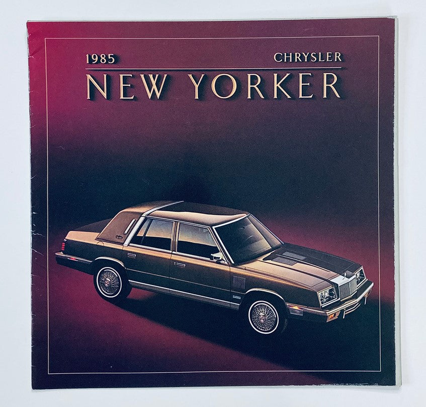 1985 Chrysler New Yorker Dealer Showroom Sales Brochure featuring a vintage car design on a dark background, showcasing the elegance and specifications of the luxury sedan.