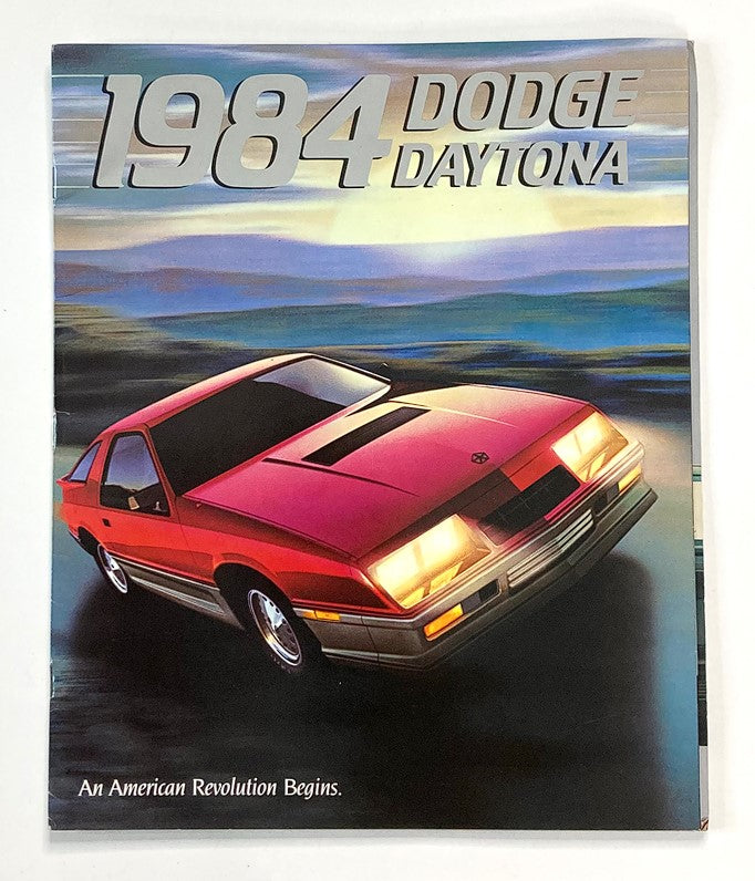 1984 Dodge Daytona Dealer Showroom Sales Brochure featuring a vibrant red Dodge Daytona sports car against a scenic background, showcasing the tagline 'An American Revolution Begins'