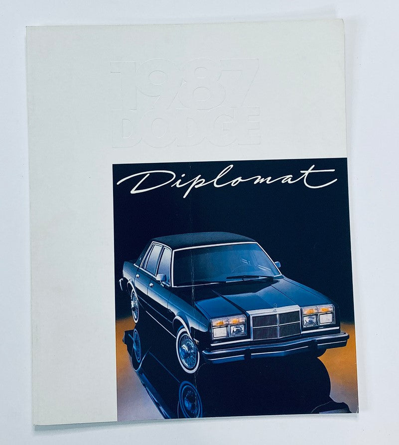 Cover of the 1987 Dodge Diplomat Dealer Showroom Sales Brochure Guide Catalog, featuring a sleek black Dodge Diplomat car.