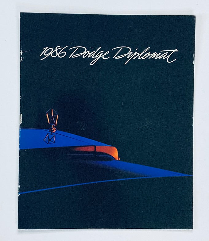 1986 Dodge Diplomat Dealer Showroom Sales Brochure showcasing the cover design, featuring a stylized illustration of a Dodge vehicle in a dark blue and orange color scheme.