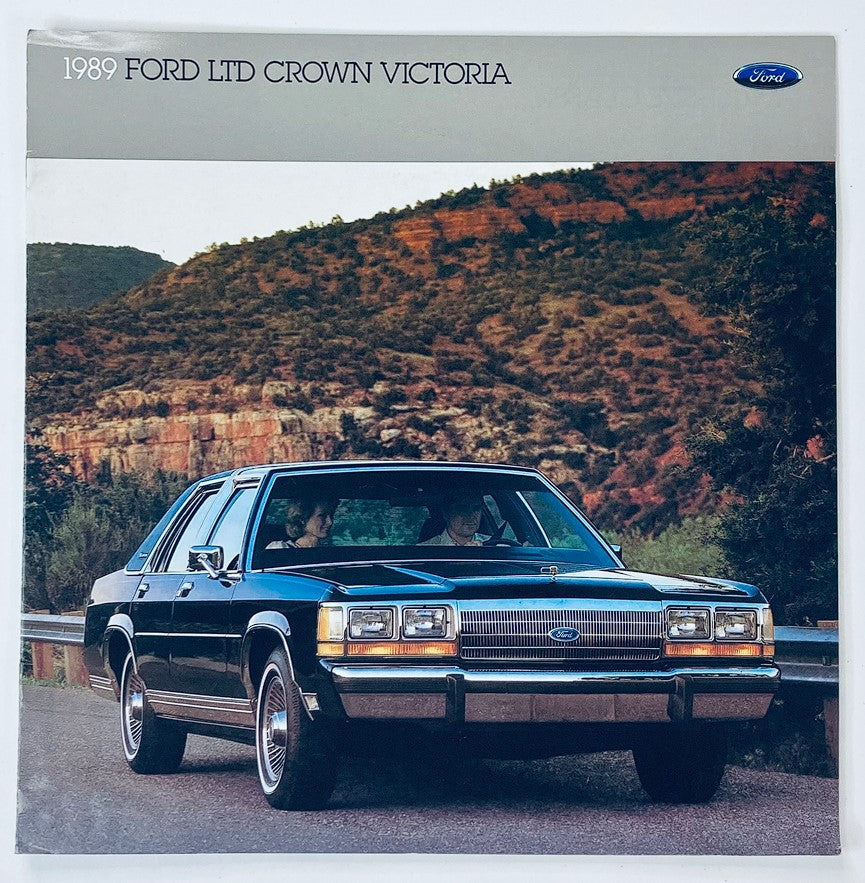 1989 Ford Ltd Crown Victoria Dealer Showroom Sales Brochure showcasing the stylish black sedan parked on a scenic route, highlighting its classic design and features.
