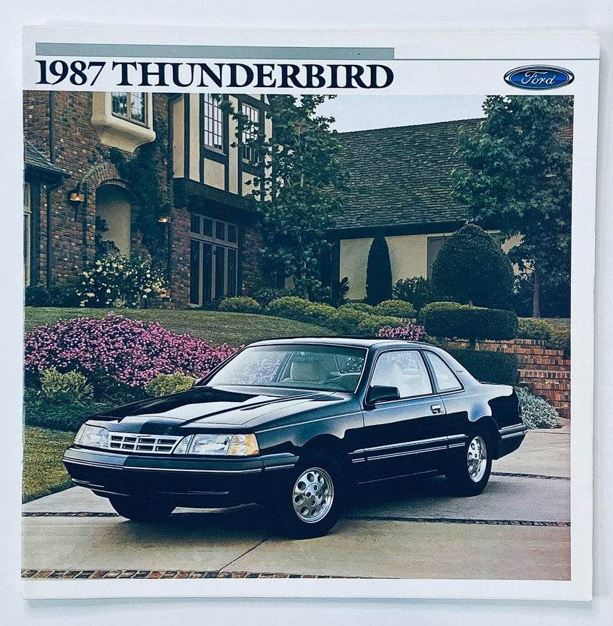 1987 Ford Thunderbird Dealer Showroom Sales Brochure Guide Catalog featuring a sleek black Ford Thunderbird parked in front of an elegant house with manicured landscaping.