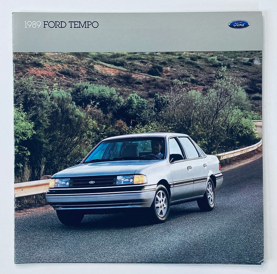 1989 Ford Tempo Dealer Showroom Sales Brochure Guide Catalog featuring a silver Ford Tempo car parked on a scenic road surrounded by greenery.