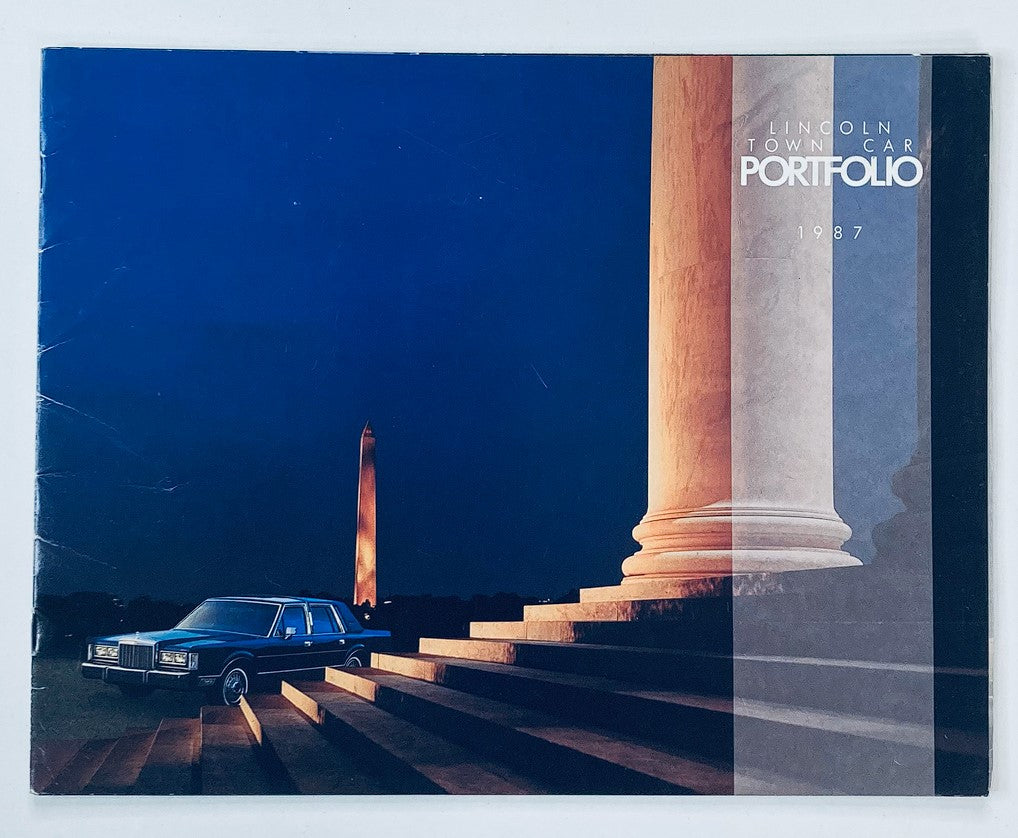 1987 Lincoln Town Car Portfolio Dealer Showroom Sales Brochure Guide Catalog featuring the car in front of a monumental structure at night with a vibrant blue sky.