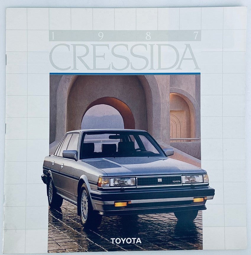 1987 Toyota Cressida Dealer Showroom Sales Brochure with a sleek silver car displayed in an artistic outdoor setting.