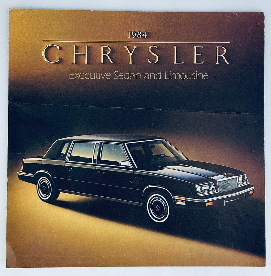 1984 Chrysler Executive Sedan Dealer Showroom Sales Brochure featuring a black Chrysler Executive Sedan, showcasing its elegant design and features in a luxurious presentation style.
