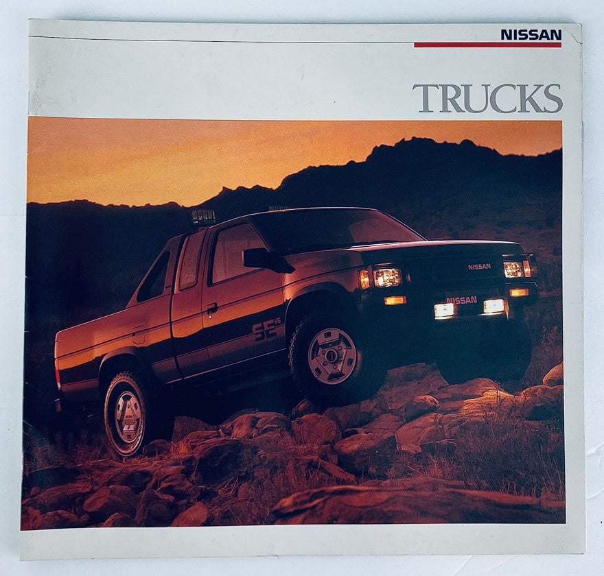1988 Nissan Trucks Dealer Showroom Sales Brochure with a Nissan truck featured against a rocky mountain backdrop, showcasing the vehicle's design and appeal.