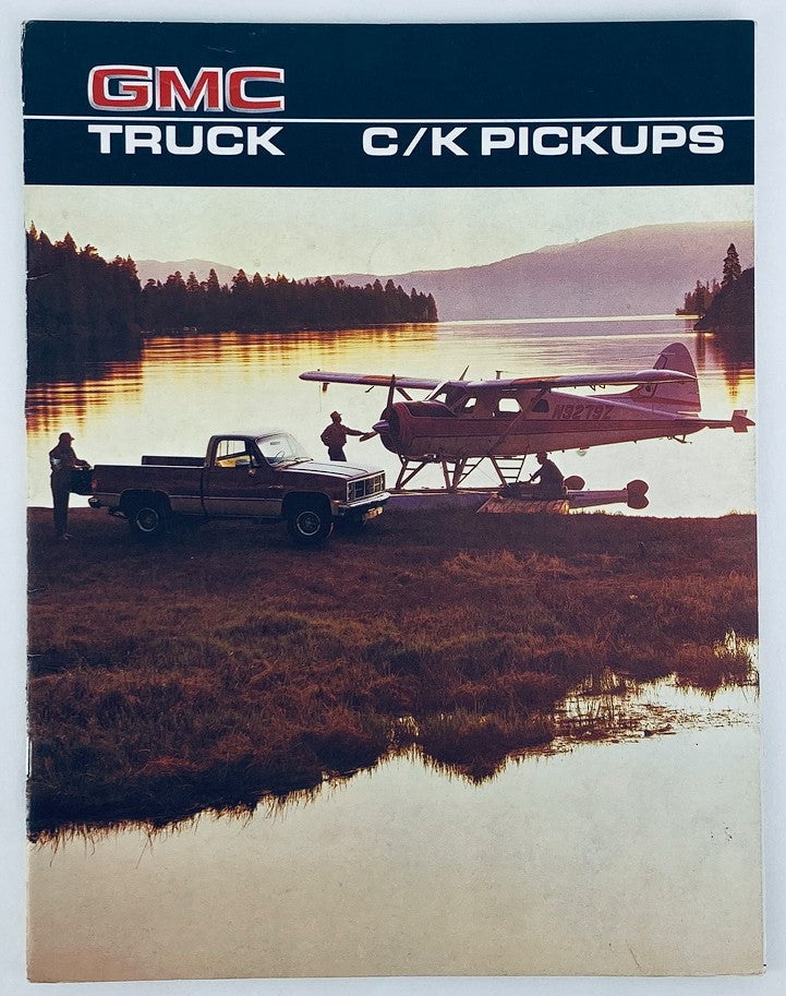 1986 GMC Truck C/K Pickups Dealer Showroom Sales Brochure showcasing the truck parked by a scenic waterfront with a small airplane in the background, perfect for collectors and enthusiasts.