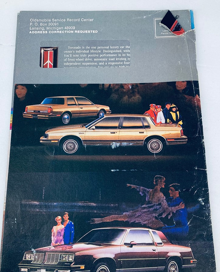 Back cover of the 1980s Oldsmobile Lineup Dealer Showroom Sales Brochure, displaying various Oldsmobile cars and emphasizing the luxurious lifestyle associated with the brand.