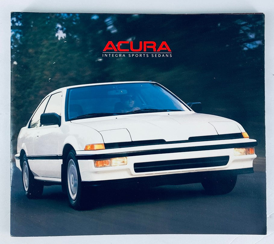 Cover of the 1988 Acura Integra Sports Sedans Dealer Showroom Sales Brochure Guide Catalog, featuring a white Acura Integra on a winding road with a blurred forest background.