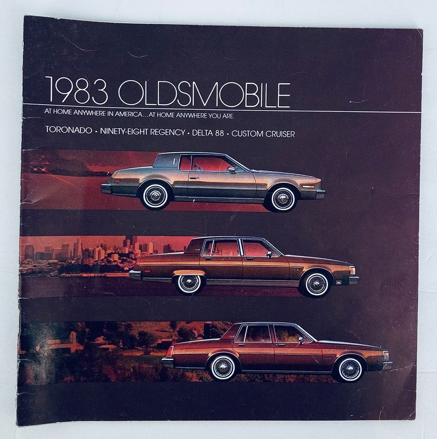 1983 Oldsmobile Toronado Dealer Showroom Sales Brochure Guide Catalog featuring three models: Toronado, Ninety-Eight Regency, and Delta 88. The brochure showcases the distinctive design of these classic cars against a stylish backdrop.