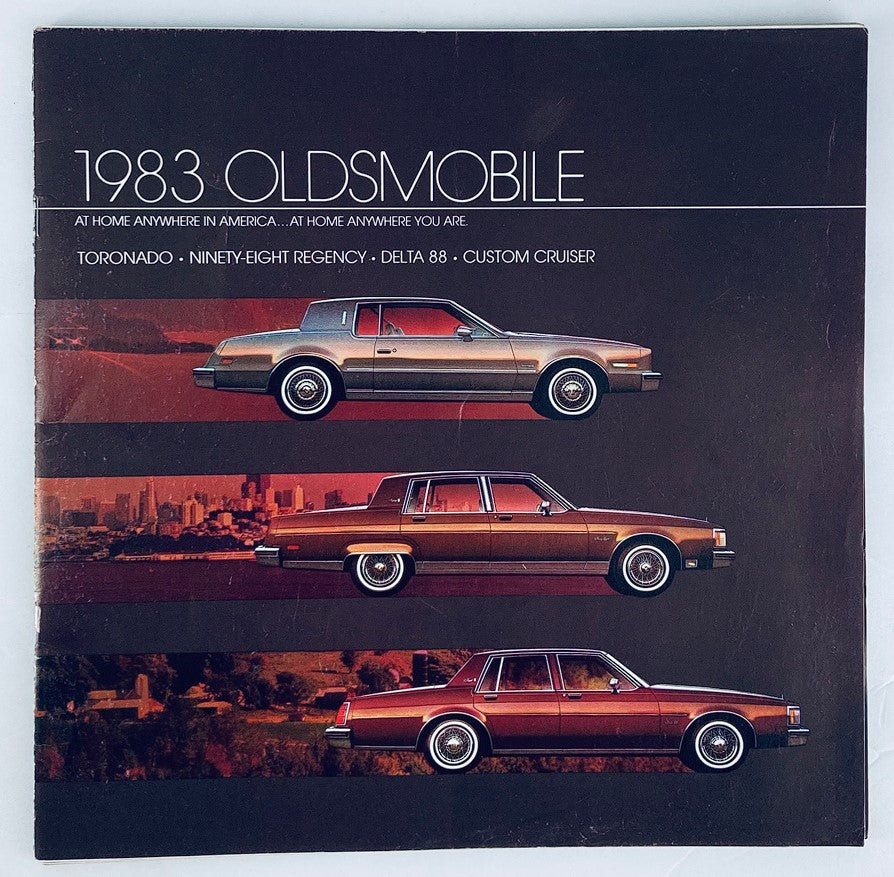 1983 Oldsmobile Custom Cruiser Dealer Showroom Sales Brochure featuring classic car illustrations, including the Oldsmobile Toronado, Ninety-Eight Regency, Delta 88, and Custom Cruiser, showcasing vibrant color contrasts and vintage advertisement style.