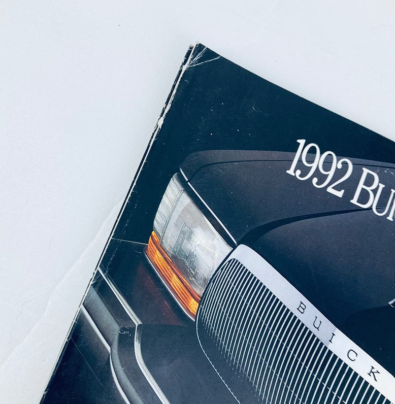 Close-up view of the 1992 Buick Roadmaster Sedan dealer showroom sales brochure highlighting the front corner with visible creases.