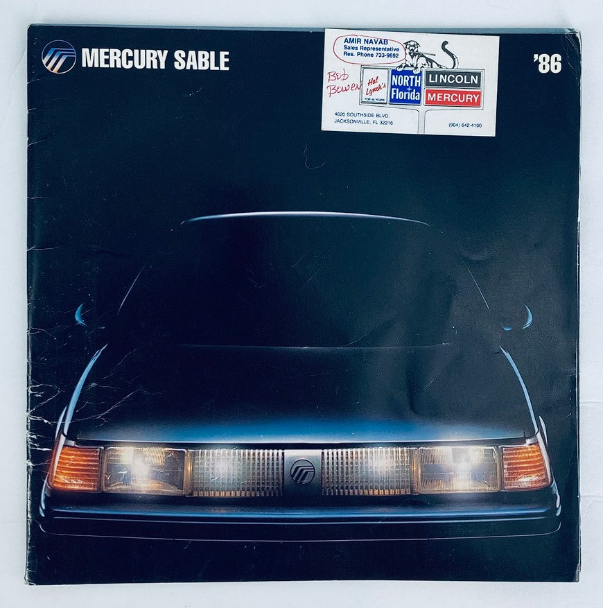 1986 Mercury Sable Dealer Showroom Sales Brochure Guide Catalog featuring a sleek front view of the car with a dark background, showcasing the vehicle's design.