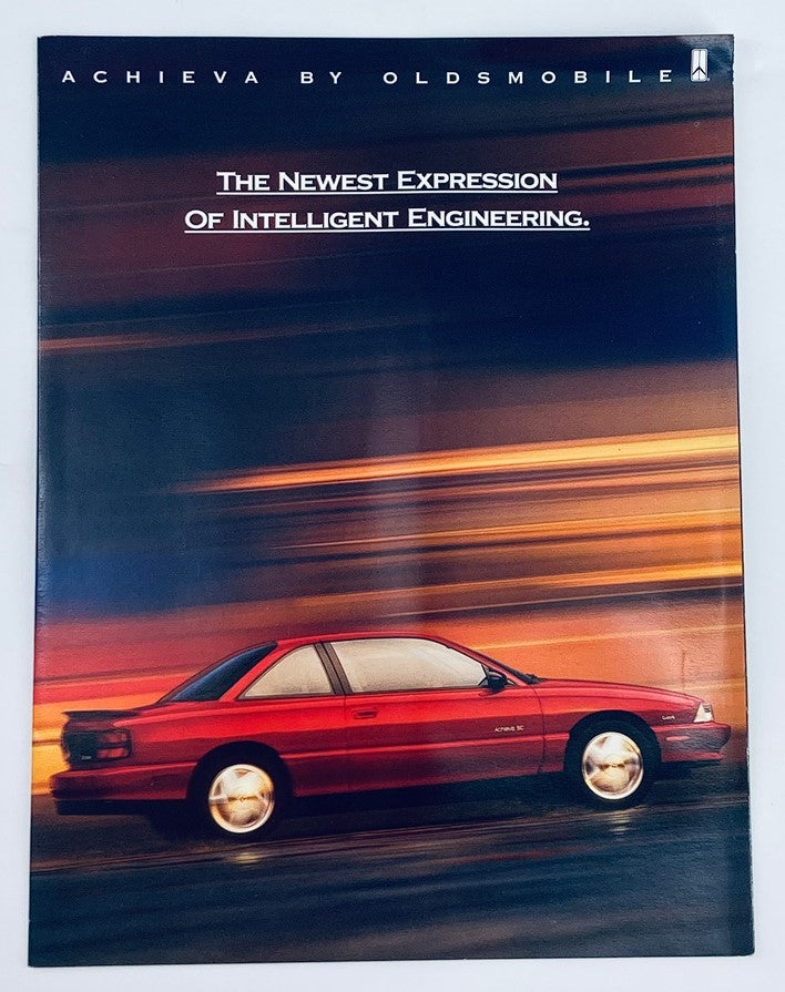 1992 Oldsmobile Achieva Dealer Showroom Sales Brochure showcasing the vehicle in motion, emphasizing its design and engineering with a dynamic background.