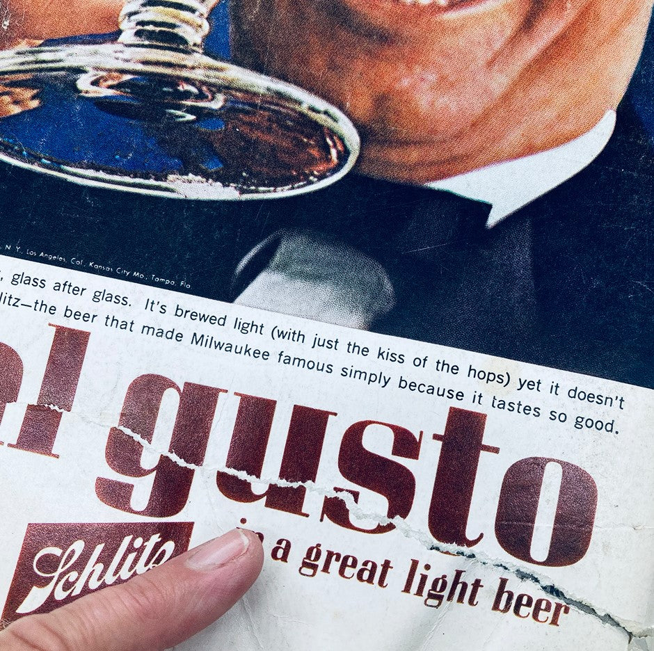 Close-up of a retro Schlitz beer advertisement from the April 1963 Playboy Magazine, highlighting a glass of beer and a smiling gentleman.